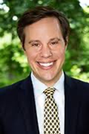 Headshot of smiling man in a suit.