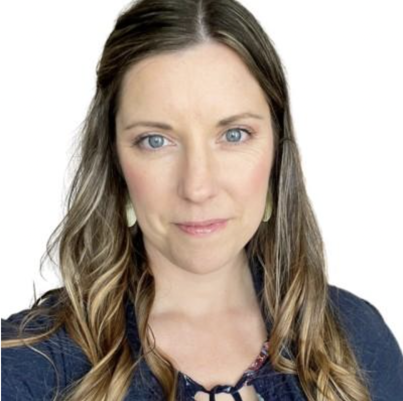 A headshot of a dark blonde woman in a blue top