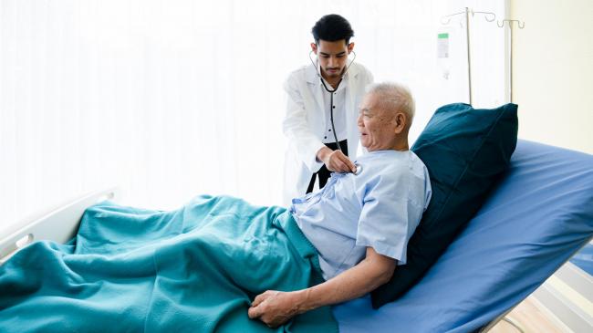 A medical student listening to a patient's heart.